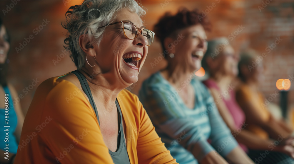 Elderly women laughing and sitting together in yoga studio.