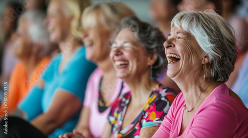 Elderly women laughing and sitting together in yoga studio.