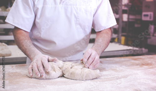 close-up on hands of baker in bakery kneading dough to bake fresh bread in the morning