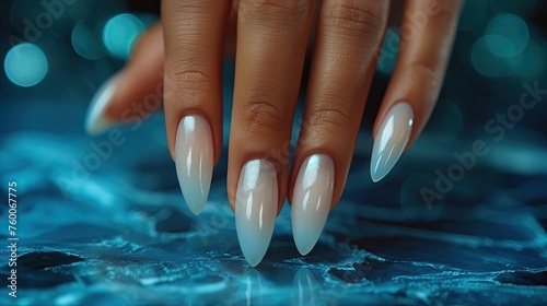 Female hand with long nails and white manicure on a blue background.