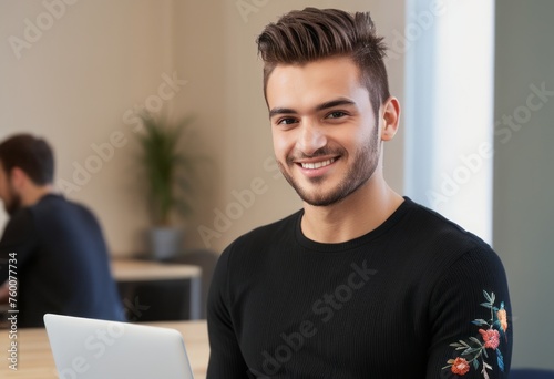 Happy man using a tablet in an office setting. Positive and modern corporate atmosphere.