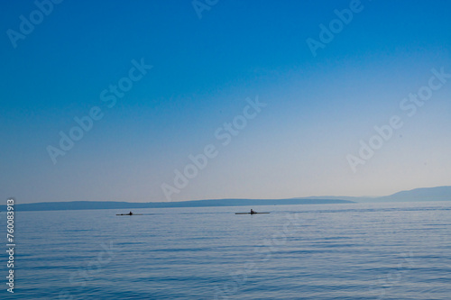 Beautiful sea with horizon. Two kayaks are floating in the distance