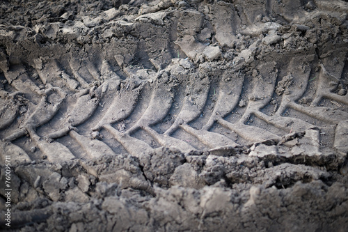 Tractor wheels imprint in raw soil. Textured abstract background © hellame