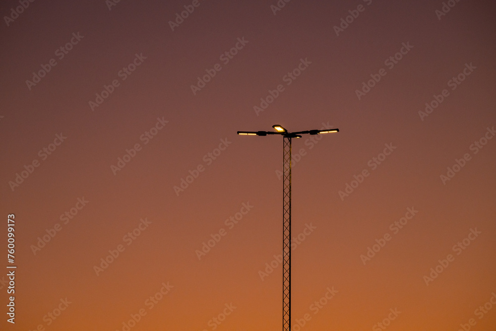 Flood lights on a tall mast in the evening. Flood lights on a tall mast in the evening.