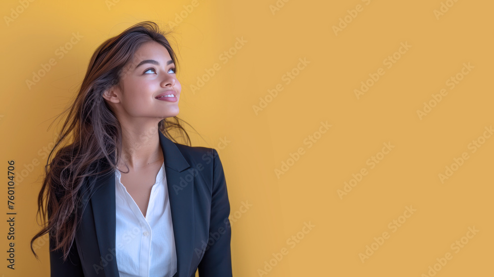 Indian businesswoman in black formal suit smiling isolated on pastel