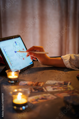Girl numerologist makes a map of codes for the future on a tablet. Veritcal photo.  photo