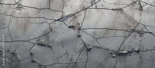 A close up of a grey cracked wall with numerous holes, creating a unique pattern. The wall is made of composite material with traces of wood and metal wires