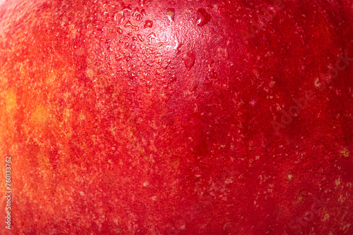 The texture of an apple is red with yellow. Apple skin with water drops.