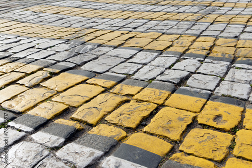 Photography Cobblestone pavement painted with white and yellow stripes, pedestrian crossing,