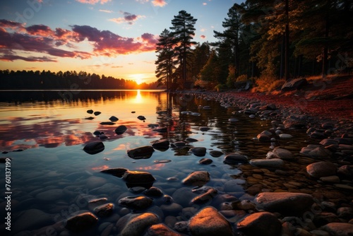 Sun setting on lake with rocky shore, creating a beautiful natural landscape