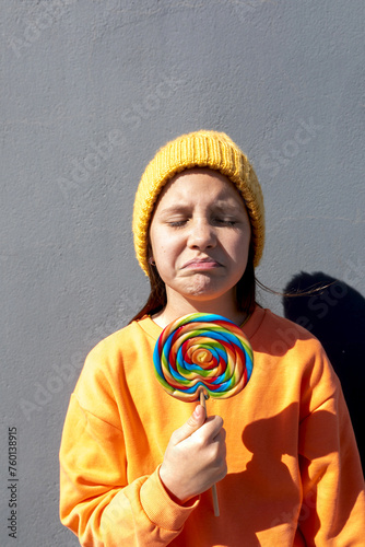 Young person with colorful lollipop on a sunny day photo