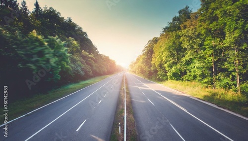 road and speed motion blur on highway in summer with green trees forest 