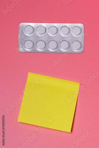 Packaging of pills and jelly sheet for notes on a pink background - health care, scheduled medication, therapy, contraception