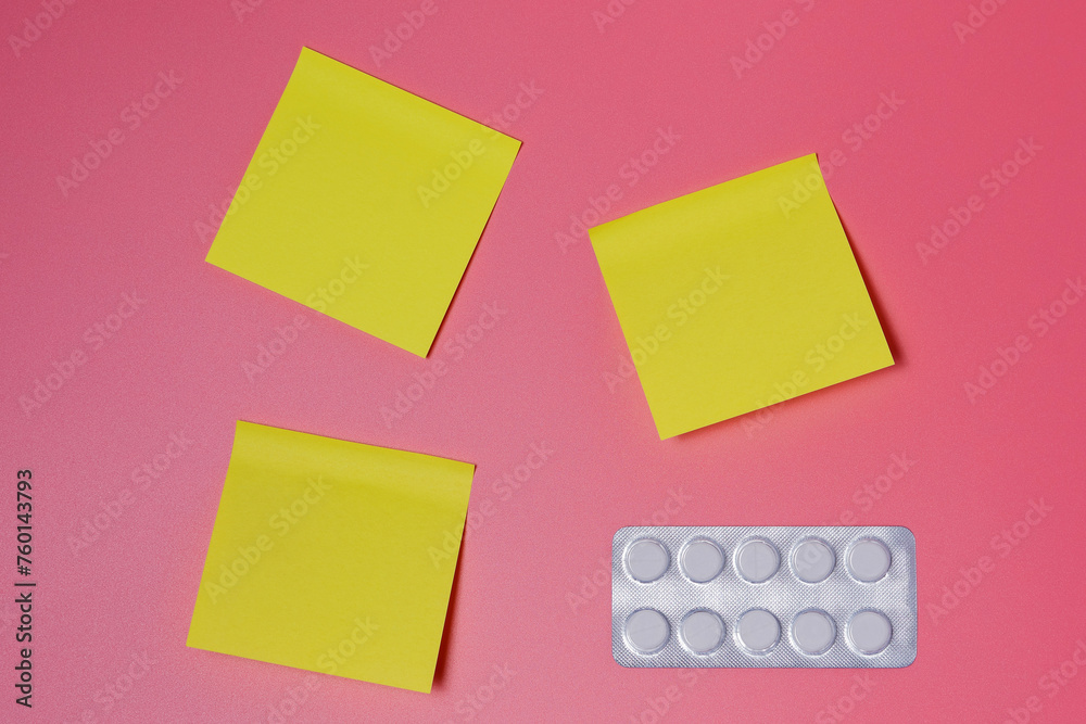 A pack of pills and a few yellow sticky notes on a pink background - healthcare, scheduled medications, therapy, contraception, schedule