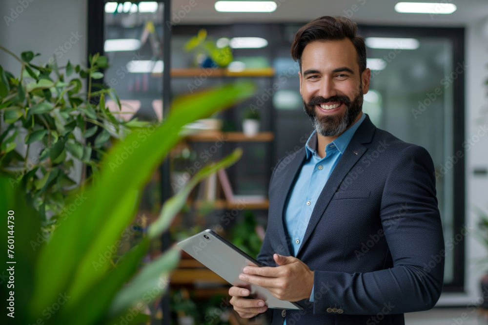 Confident entrepreneur with tablet in green office space. A charismatic businessman smiling while holding a tablet in a modern office filled with green plants. Confident entrepreneur with tablet in green office space. A charismatic businessman smiling while holding a tablet in a modern office filled with green plants.