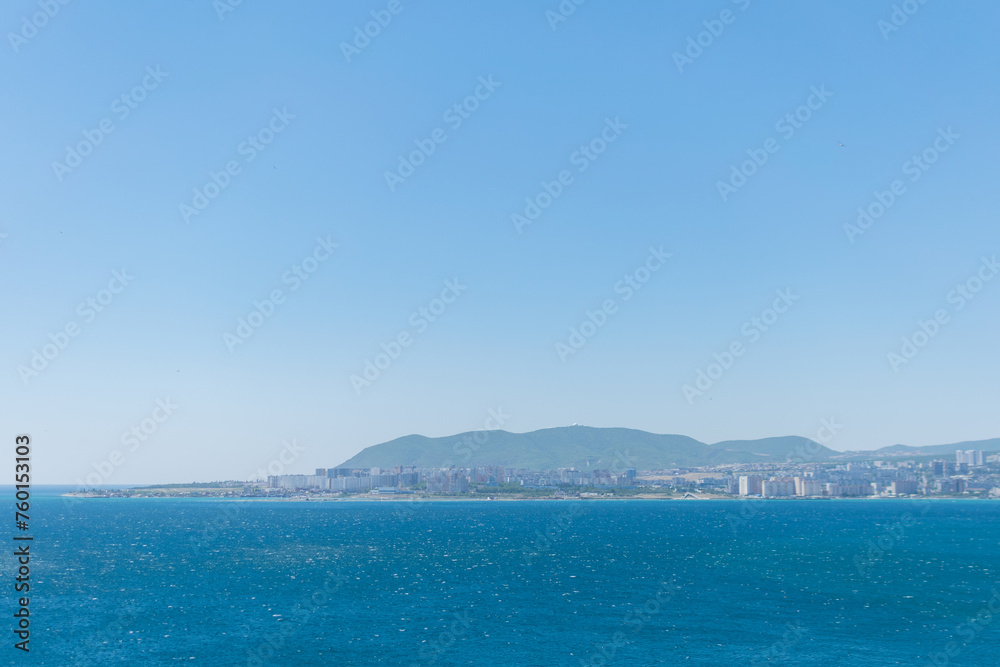 Sea horizontal landscape - blue sky, blue sea, mountain hills on the horizon