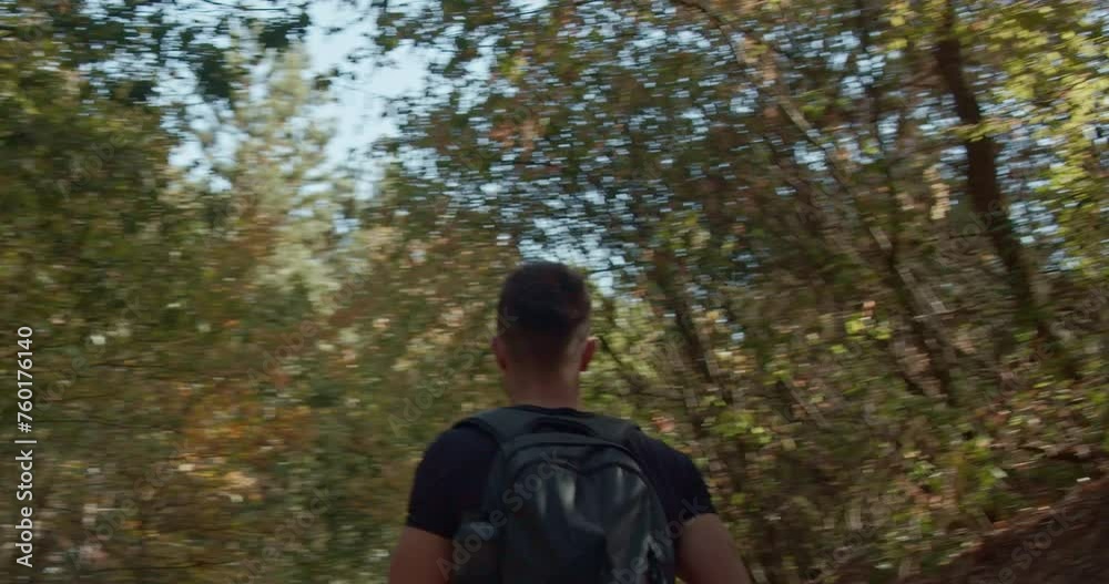 Good looking, fit man going home after hiking all day in the mountain. He is walking on a trail and enjoying the beautiful, green, natural environment. Good looking, fit man going home after hiking all day in the mountain. He is walking on a trail and enjoying the beautiful, green, natural environment.
