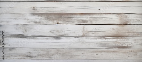 A closeup of a rectangular white wooden wall with a hardwood flooring in grey color. The wood texture creates a beautiful brickwork pattern