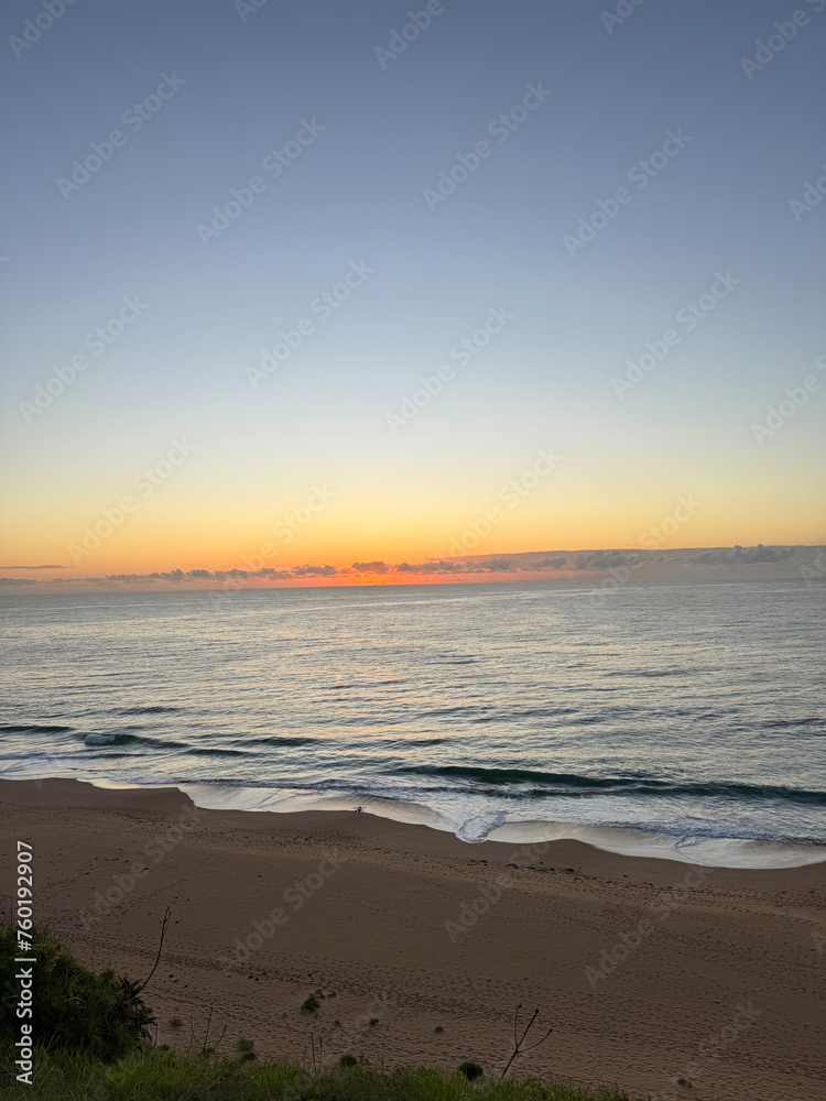 Sunrise at a beach in Summer in Australia overlooking the horizon and ocean