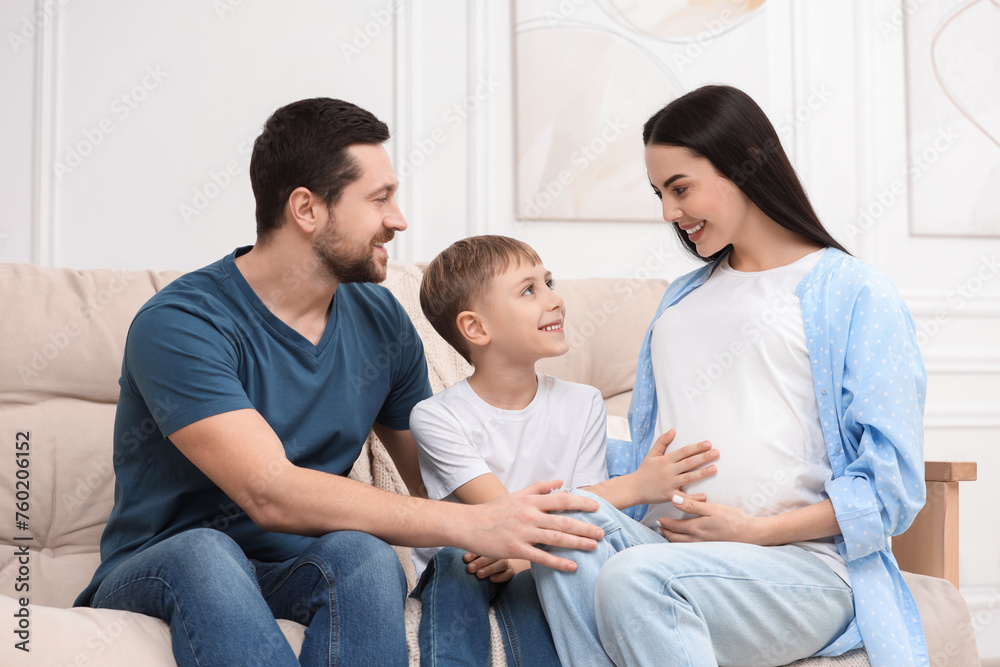 Pregnant woman spending time with her son and husband at home. Happy family Pregnant woman spending time with her son and husband at home. Happy family