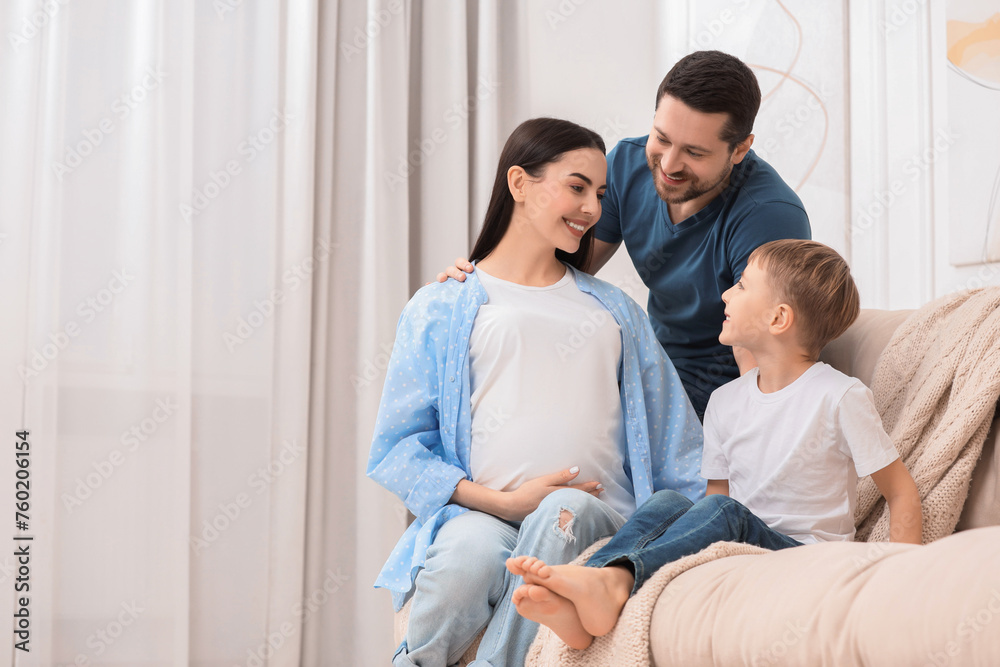 Pregnant woman spending time with her son and husband at home, space for text. Happy family Pregnant woman spending time with her son and husband at home, space for text. Happy family