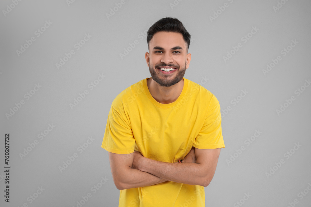Handsome young man laughing on grey background Handsome young man laughing on grey background