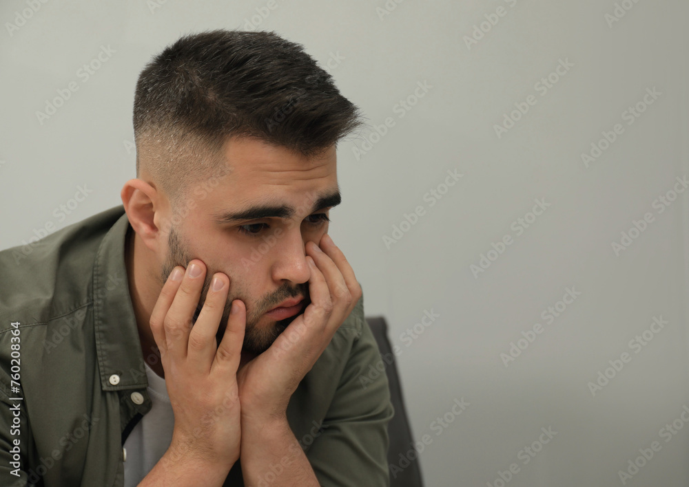 Portrait of sad man near light grey wall. Space for text Portrait of sad man near light grey wall. Space for text