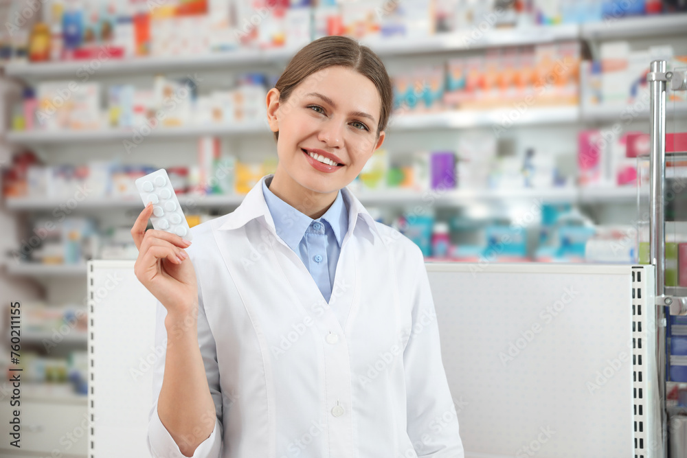 Fototapeta premium Professional pharmacist with pills in modern drugstore