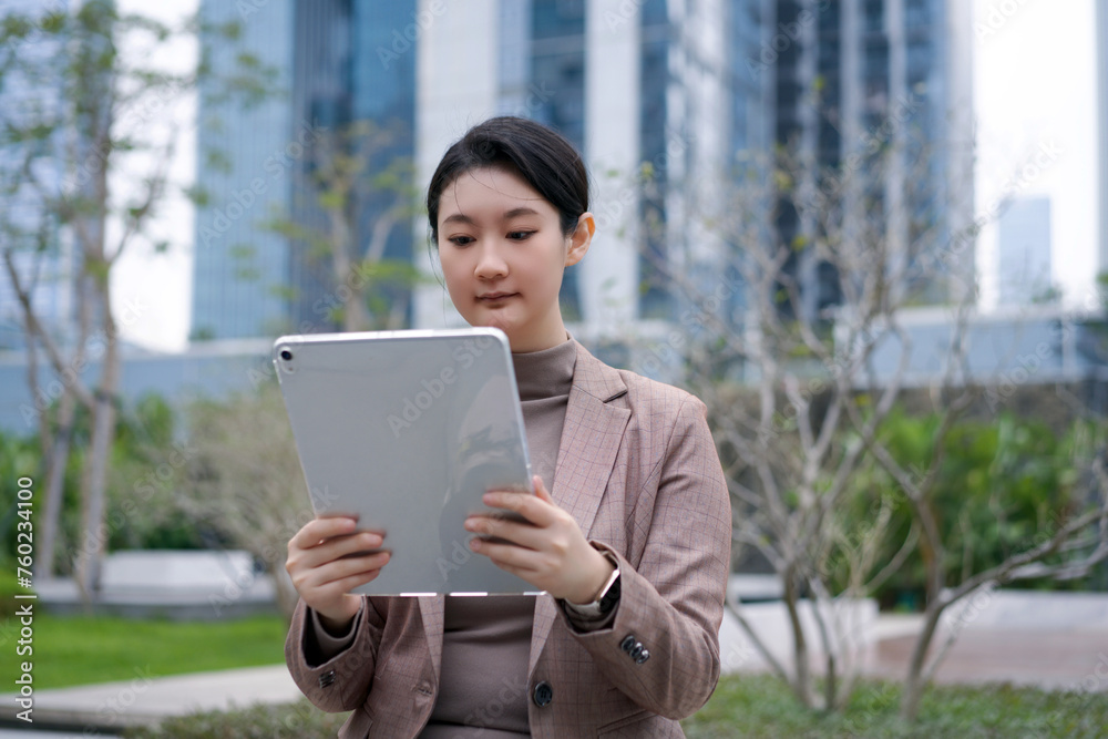 Businesswoman Focused on Tablet Outside Office Building Businesswoman Focused on Tablet Outside Office Building