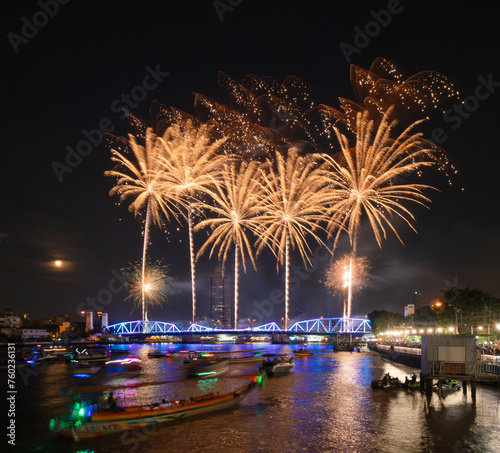 Fireworks at Memorial Bridge, and Phra Pok Klao Bridge with buildings and Chao Phraya River at night. Urban city, Downtown Bangkok, Thailand.