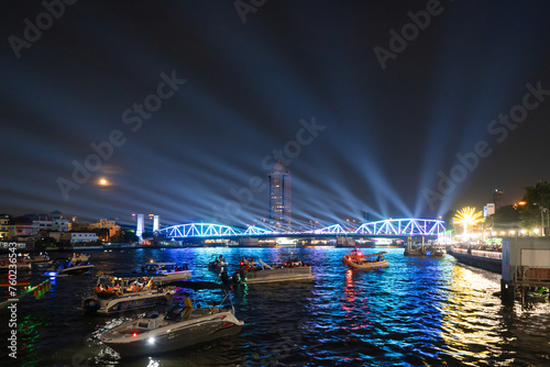 Memorial Bridge, and Phra Pok Klao Bridge with buildings and Chao Phraya River at night. Urban city, Downtown Bangkok, Thailand.