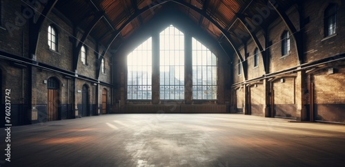 Empty spacious hall with large arched windows and sunlight streaming in, ideal for events or as a vintage interior backdrop. © AdibaZR