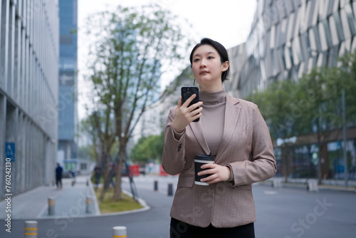 Professional Woman Checking Smartphone on City Street