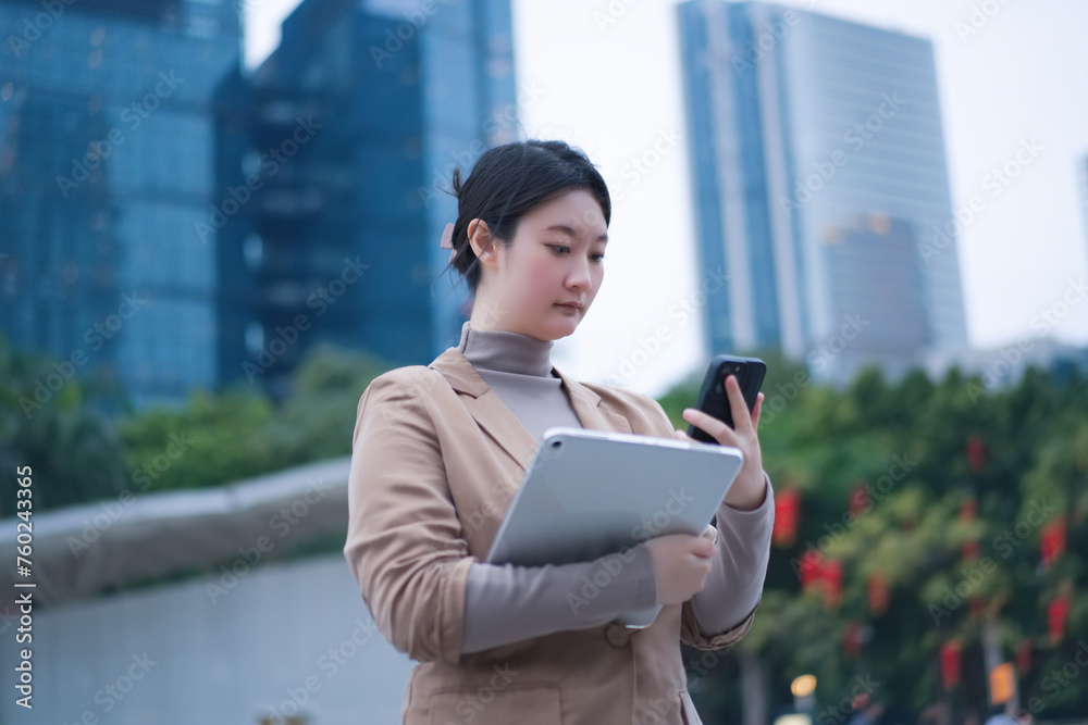 Fototapeta premium Businesswoman Multitasking with Tablet and Phone