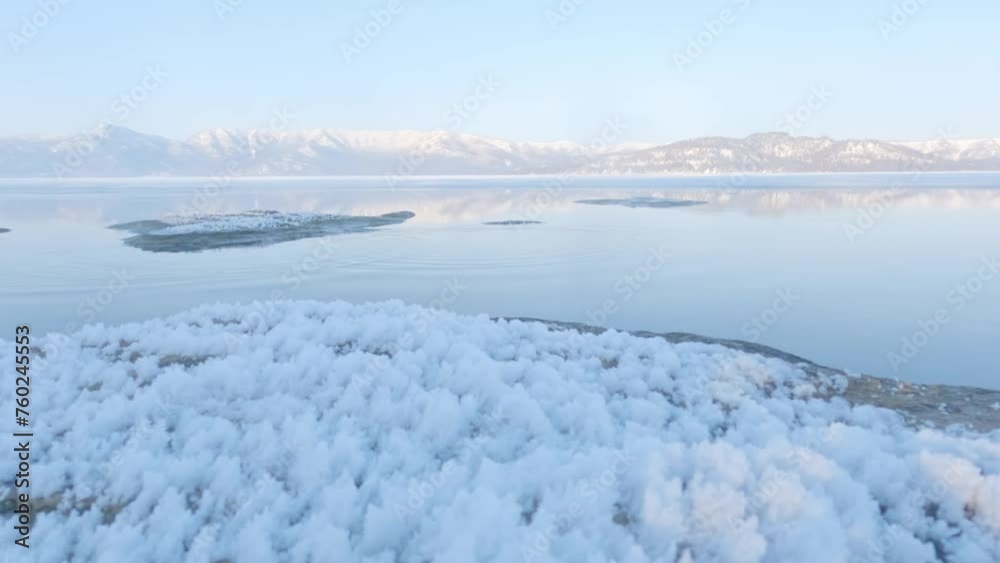 Ripples on calm lake surface in frozen winter landscape, Hokkaido, Japan Ripples on calm lake surface in frozen winter landscape, Hokkaido, Japan