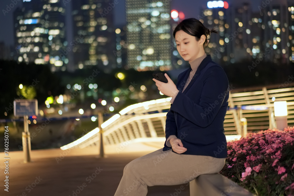 Young Woman on Smartphone in City at Night