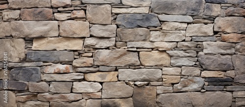 A detailed close up of a stone wall made with a multitude of rectangular beige bricks. The intricate brickwork showcases the natural beauty of this composite material