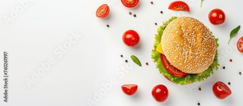 Top view of delicious burger with tomatoes, cheese slices and lettuce on white background.