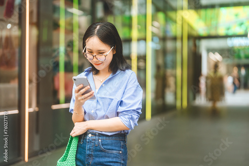 Business asian woman using smartphone city lifestyles with casual fashion positive look