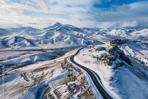 Aerial view of a winter landscape with road and mountains