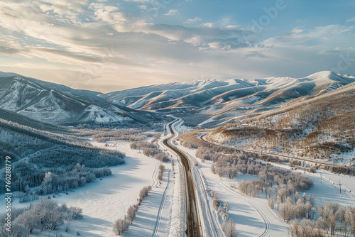 Aerial view of a winter landscape with road and mountains