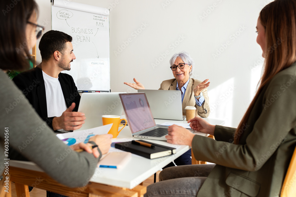 Three young people and one mature woman on a business meeting in the office. Three young people and one mature woman on a business meeting in the office.