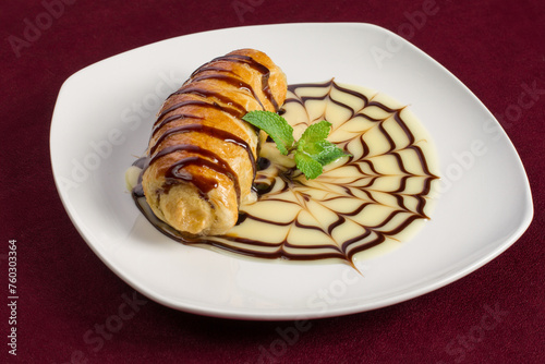 Puff pastry dessert with filling inside on a white plate, menu for a restaurant