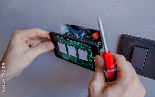 Technician installing sensor light switch at modern villa