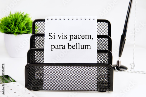 Si vis pacem, para bellum. Latin phrase meaning If you want peace, prepare for the war. on a white sheet of a notebook in a black stand. Concept photo photo