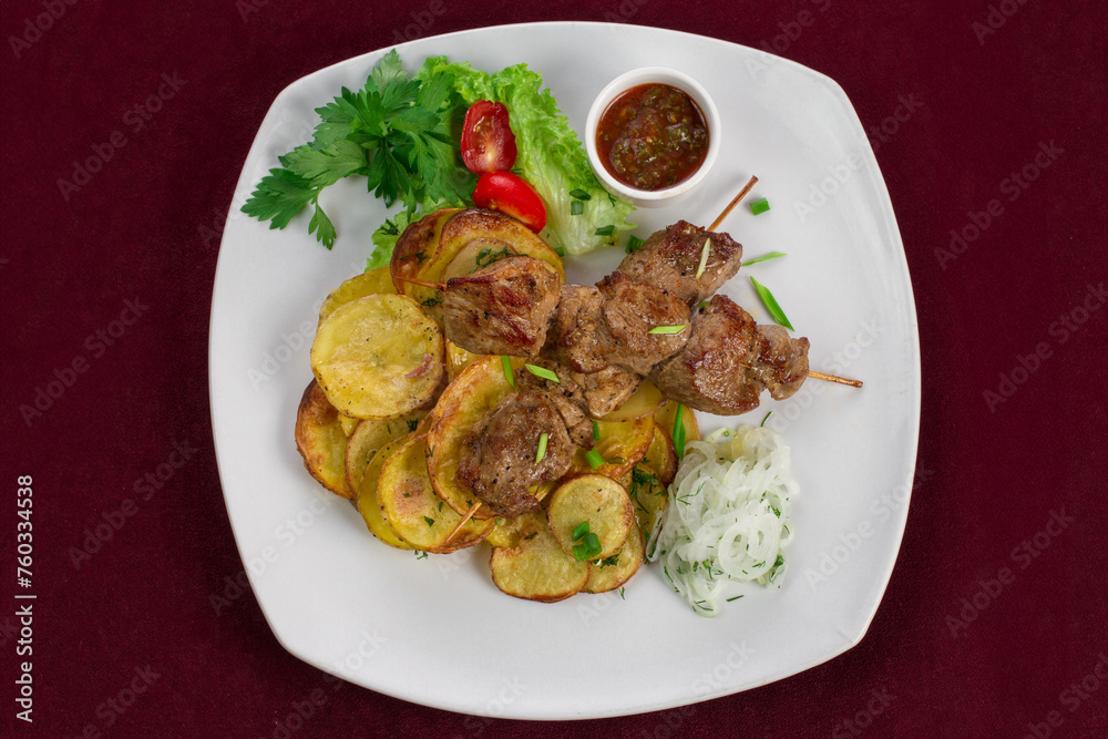 Delicious kebab with fried potatoes on a plate, menu for a restaurant