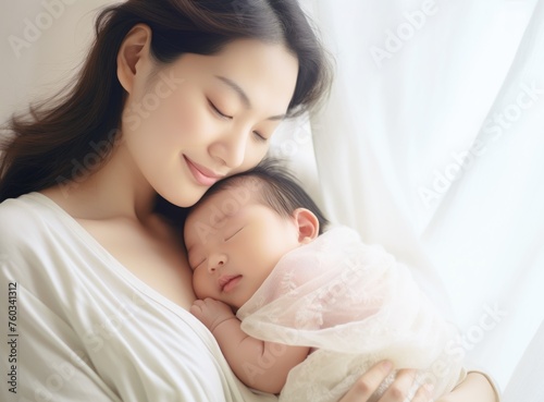 close up portrait of happy young mother holding sleeping newborn baby