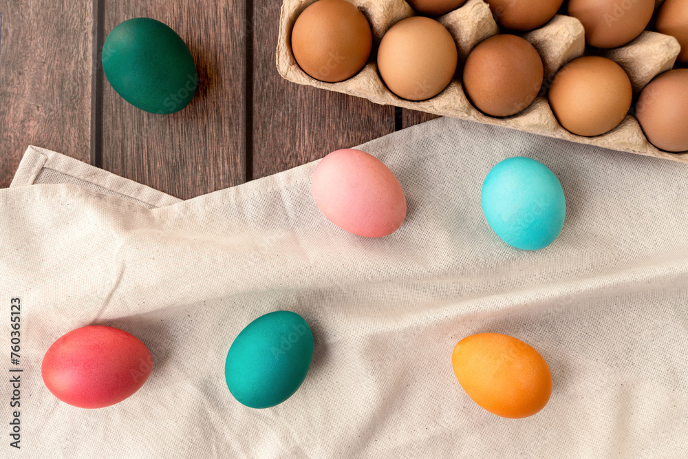 a bunch of colorful eggs are sitting on a towel on a table . High quality a bunch of colorful eggs are sitting on a towel on a table . High quality