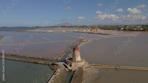 Salt Pans near Marsala at Sicily, Italy in Europe. colorful windmills at the saltpans of Sicily in summer at sunset photo
