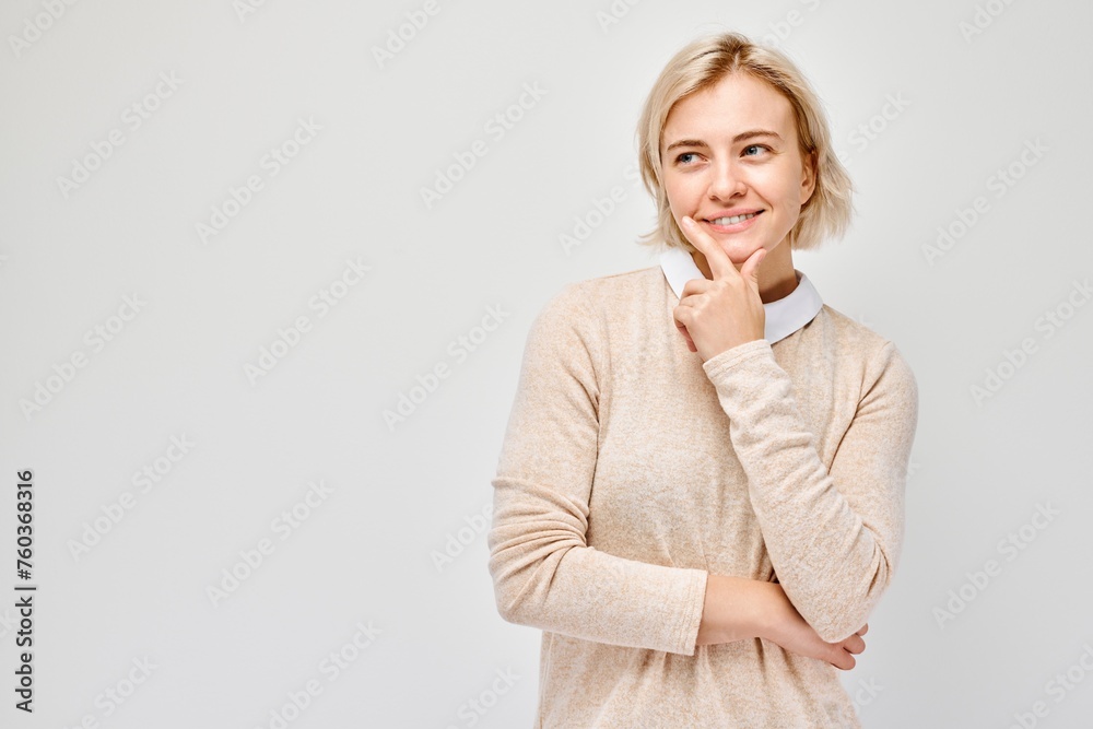 Smiling woman with hand on chin, looking thoughtful, isolated on light background. Smiling woman with hand on chin, looking thoughtful, isolated on light background.